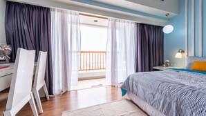Una camera da letto con un letto, una scrivania e vista sul balcone.