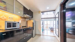 Una cucina moderna con microonde, frigorifero e mobili scuri.