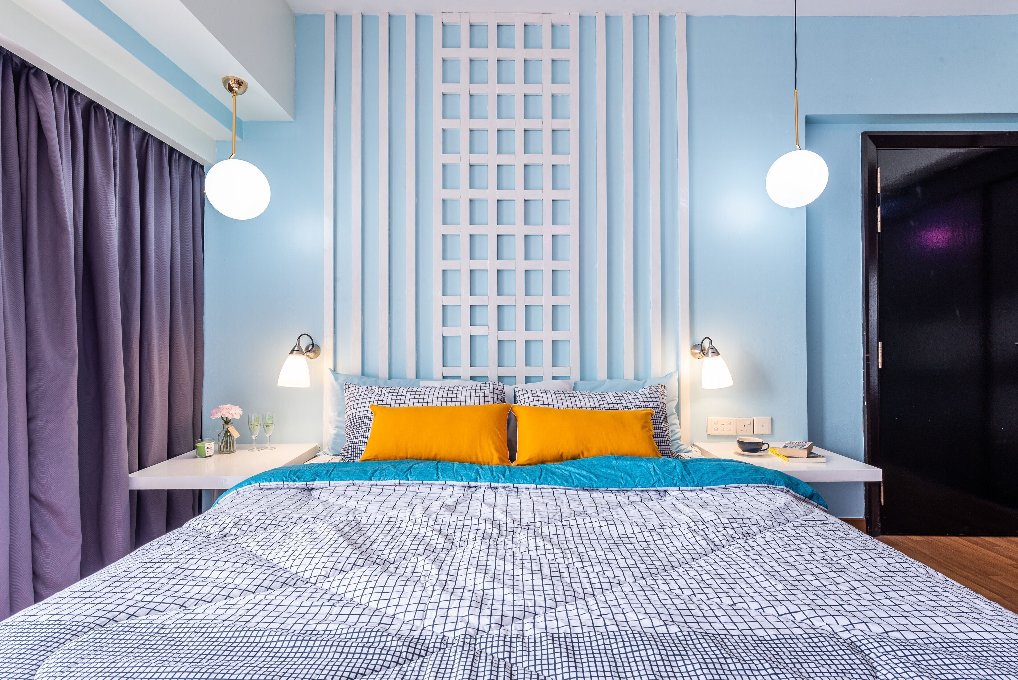 A modern bedroom with a large bed, two bedside tables, a nightstand, a window with blinds, and a door.