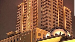 Un hotel moderno con numerosi balconi e una struttura a forma di cupola alla base.