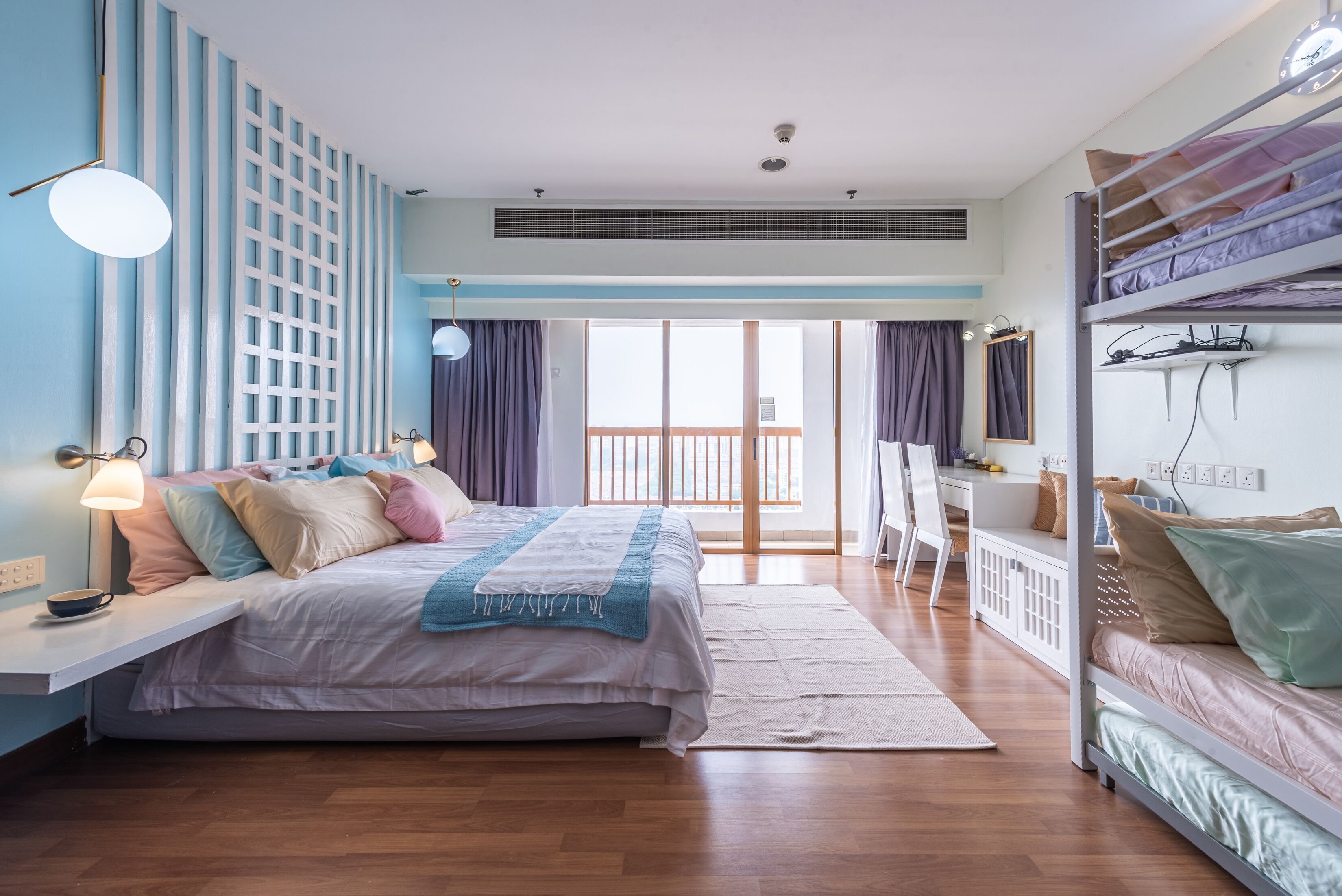 Ein Schlafzimmer mit Bett, Nachttisch, Lampe und Blick ins Freie.