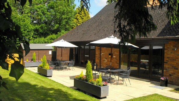 A patio area with outdoor seating and planters. - Henley Hotel (Henley-in-Arden)