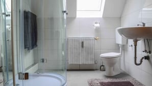 A modern bathroom with a glass shower enclosure, a white toilet, and a sink with a wooden basin. - Monteurzimmer & FeWo G. Klement Aurach (Herrieden)