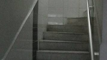 Una escalera con barandilla que lleva a una pared de azulejos con un cuadro enmarcado.