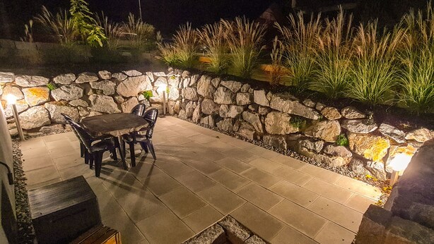 An outdoor patio with stone walls, a table, and chairs. - Apartment in a very quiet location, 12 km to Europa Park Rust (Herbolzheim)