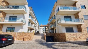 Ein modernes Wohngebäude mit mehreren Balkonen, Ziegel Fassaden und blauem Himmel.