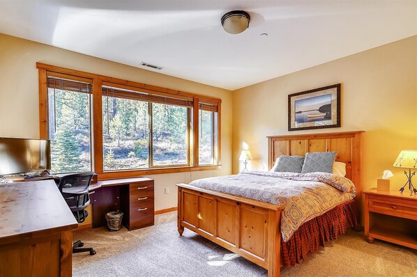 A bedroom with a large window, a bed, a desk, and a nightstand. - The Dolomite Getaway #6 (Truckee)