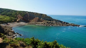 A coastal landscape with rocky cliffs, clear turquoise waters, and lush greenery. - Lighthouse - 3 story holiday home with shared tennis court and sea views (São Martinho do Porto)