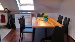 A dining area with a wooden table, six chairs, and a small plant. - Fewo Holbeinstr 8 - 2 Schlafzimmer P (Erfurt)