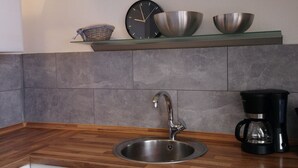 A kitchen with a stainless steel sink, a coffee maker, and a clock on the wall. - Fewo Holbeinstr 8 - 2 Schlafzimmer P (Erfurt)