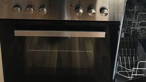 A stainless steel oven with a black control panel and a built-in dishwasher.