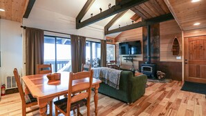 A wooden interior with a dining table, chairs, a sofa, and a fireplace. - Bigwood 80 Remodeled, Private Washer Dryer, Close to Eagle Lodge by RedAwning (Mammoth Lakes)