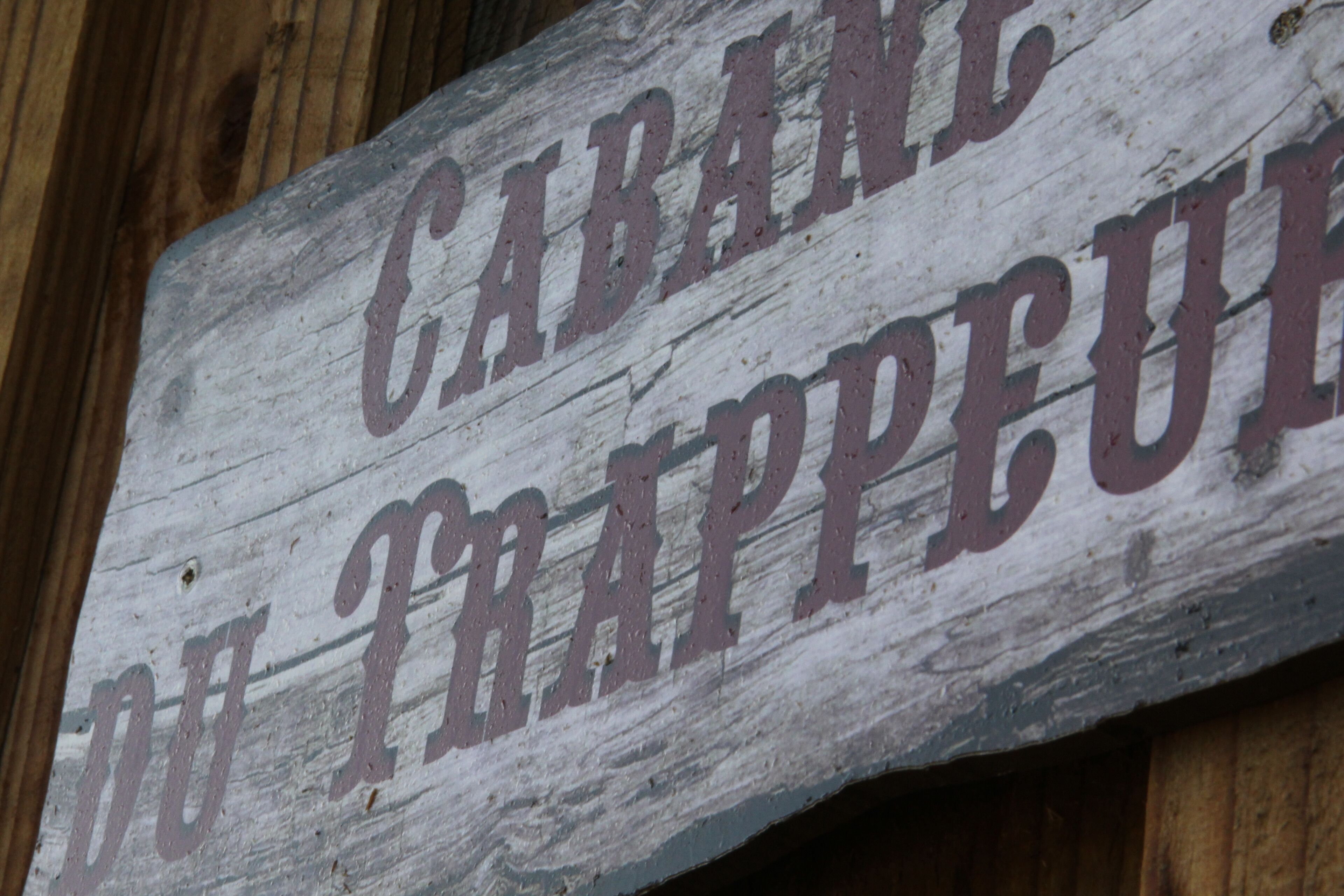 A wooden sign with the text "CABAN DE TRAPPEU" in a rustic font.