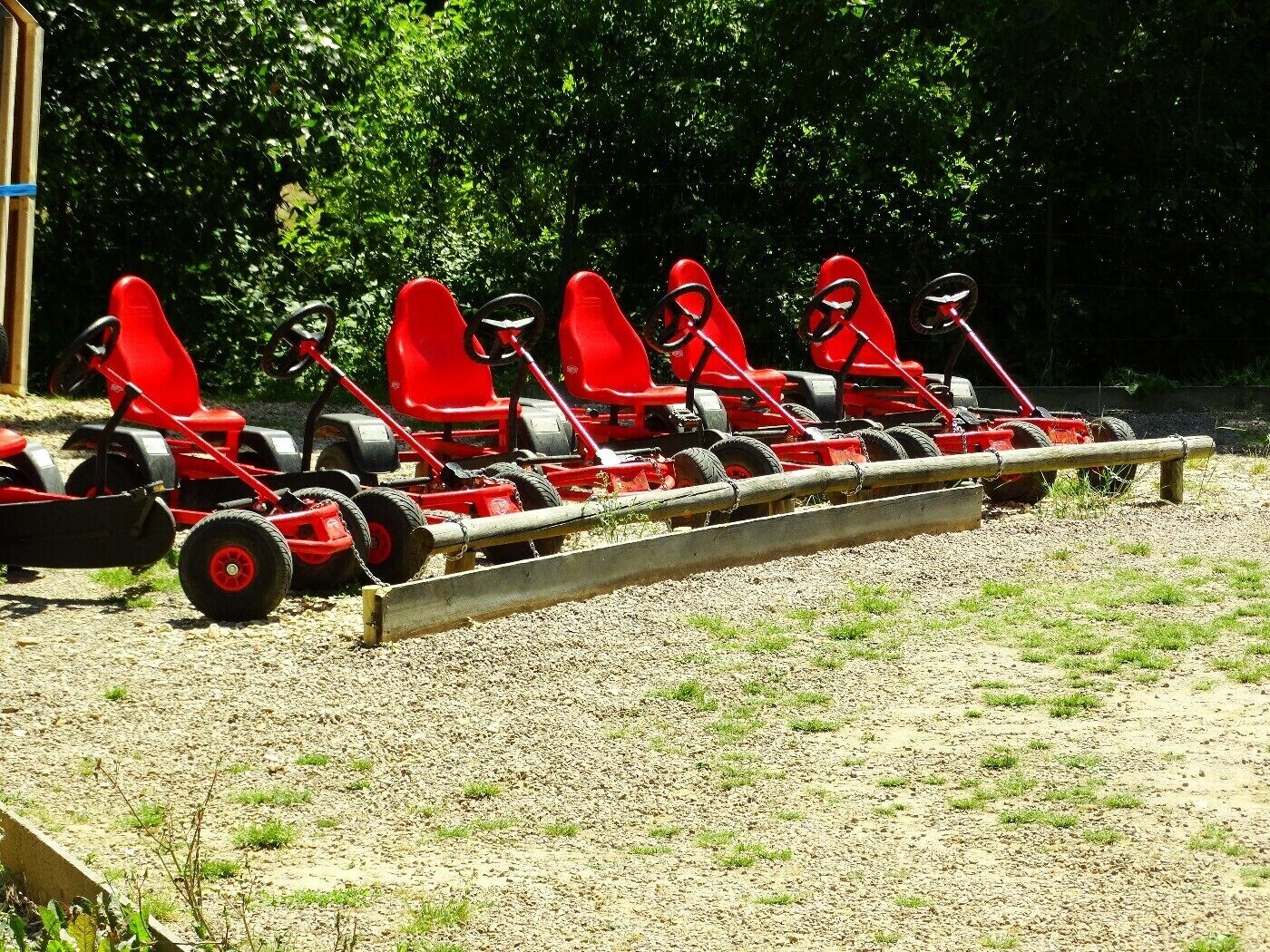 A row of red lawn mowers lined up outdoors.