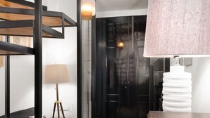 A modern interior with a bunk bed, a desk, a lamp, and a black door. - National Theater House 24 (Porto)