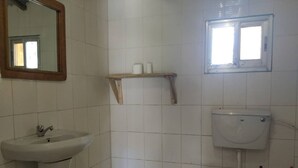 Un baño pequeño con lavamanos, inodoro y ventana.