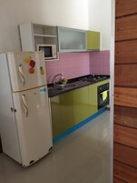 Una cocina con un refrigerador blanco, un microondas, una estufa y un lavamanos.