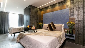 A modern hotel room with a large bed, a nightstand, and a wall-mounted TV. - 2 Luxury Rooms With Window (Medellín)