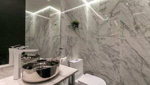 A modern bathroom with a large marble sink, a toilet, and a glass shelf with a plant. - 2 Luxury Rooms With Window (Medellín)