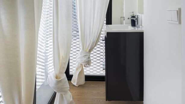 A narrow hallway with white curtains, a black cabinet, and a mirror on the wall. - Genteel Home Mateos Gago Terrace (Seville)