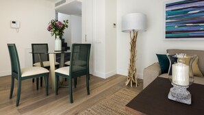 A modern living room with a dining area, a floor lamp, and a painting on the wall. - Genteel Home Mateos Gago Terrace (Seville)