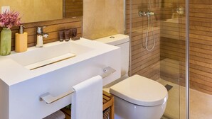 A modern bathroom with a white vanity, a glass-enclosed shower, and a beige tiled wall. - Genteel Home Murillo II (Seville)