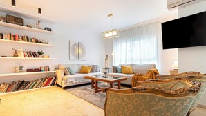 Un salon comprenant un canapé, un fauteuil, une table basse et des étagères.