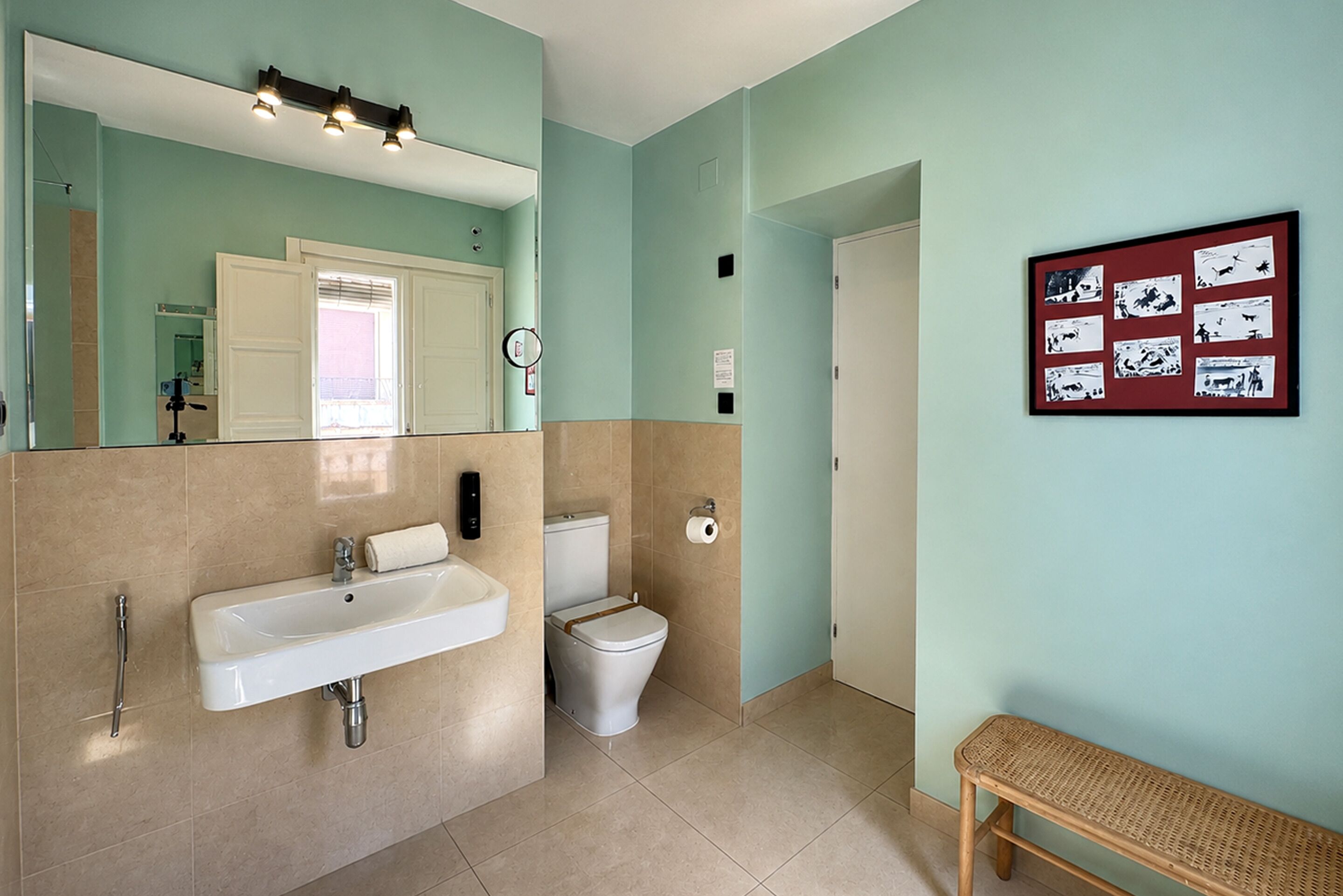 A bathroom with a sink, toilet, and a mirror.