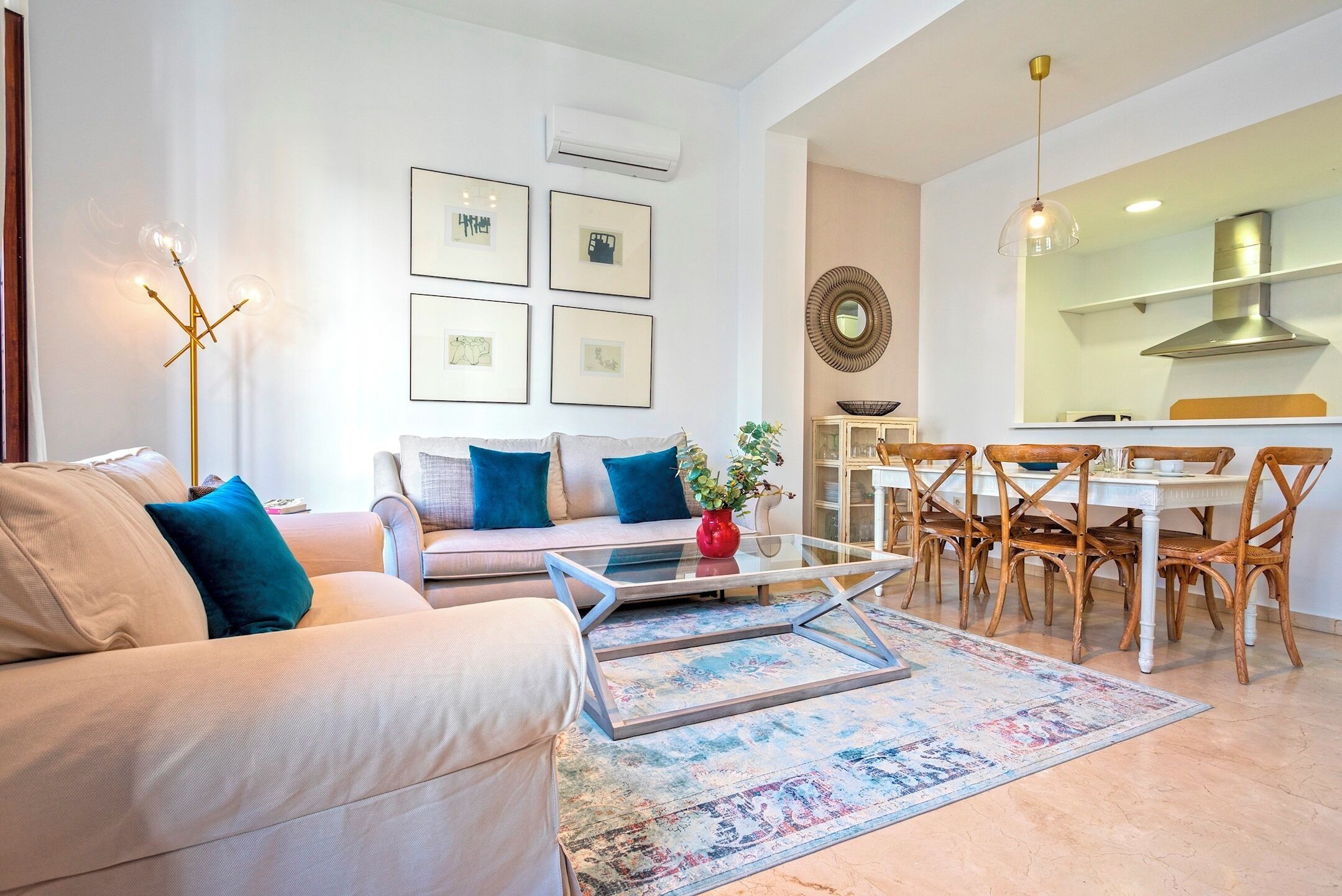 A living room with a sofa, coffee table, and dining area with chairs and a table.