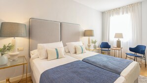 A hotel room with two beds, a desk, two chairs, and a window with curtains. - Genteel Home Francos Terrace VI (Seville)