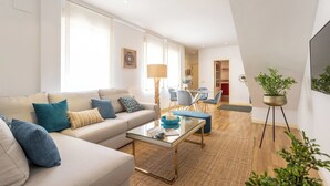A modern living room with a sofa, coffee table, and a potted plant. - Genteel Home Francos Terrace VI (Seville)