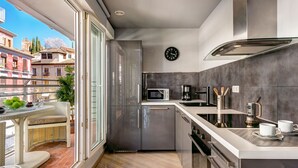 Eine moderne Küche mit einem großen Fenster, einer Mikrowelle, einer Kaffeemaschine und einer Wanduhr.
