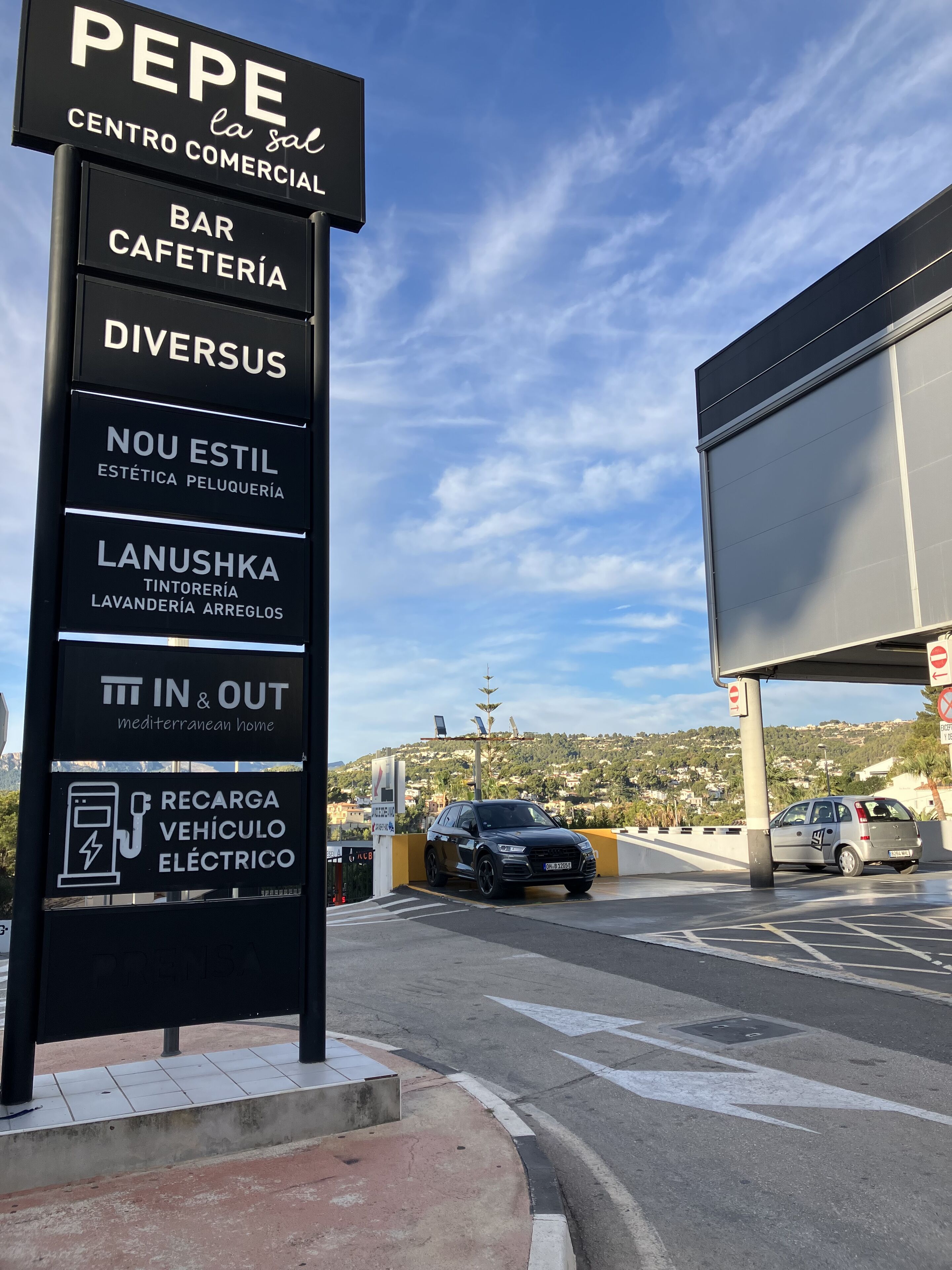 Een bordje waarop diverse voorzieningen staan vermeld, zoals een bar, een cafeteria en een huis in mediterrane stijl.