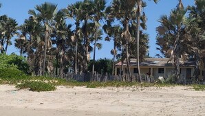 A sandy beach with palm trees and a small building with a red roof. - Unspoiled South Gambian Paradise '' Pure Nature Treehouse '' (Kartung)