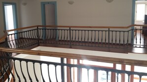 A spacious interior with a wooden staircase and a balcony railing. - Posejdon (Ulcinj)