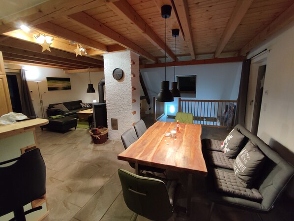 Ein gemütliches Wohnzimmer mit einem Holzesstisch, einer Couch und einem Kamin.