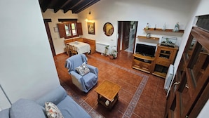Een woonkamer met een bank, een salontafel, een tv-meubel en een eethoek met een tafel en stoelen.