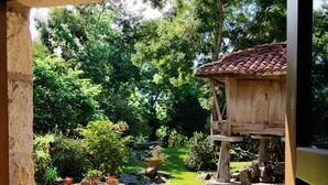 Ein Garten mit einer Holzkonstruktion, Steinstufen und Topfpflanzen.