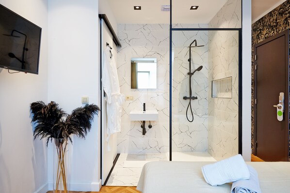 Une salle de bain moderne avec une douche à parois de verre, un lavabo et un miroir.