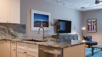 A modern kitchen with a marble countertop, stainless steel appliances, and a large island.