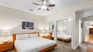 A hotel room with a bed, bedside lamps, a ceiling fan, a framed picture on the wall, and a mirror. - Mesa House Uno - One block from Duval St (Key West)
