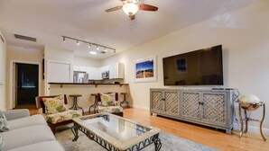 A living room with a sofa, coffee table, TV, and a cabinet. - Mesa House Uno - One block from Duval St (Key West)