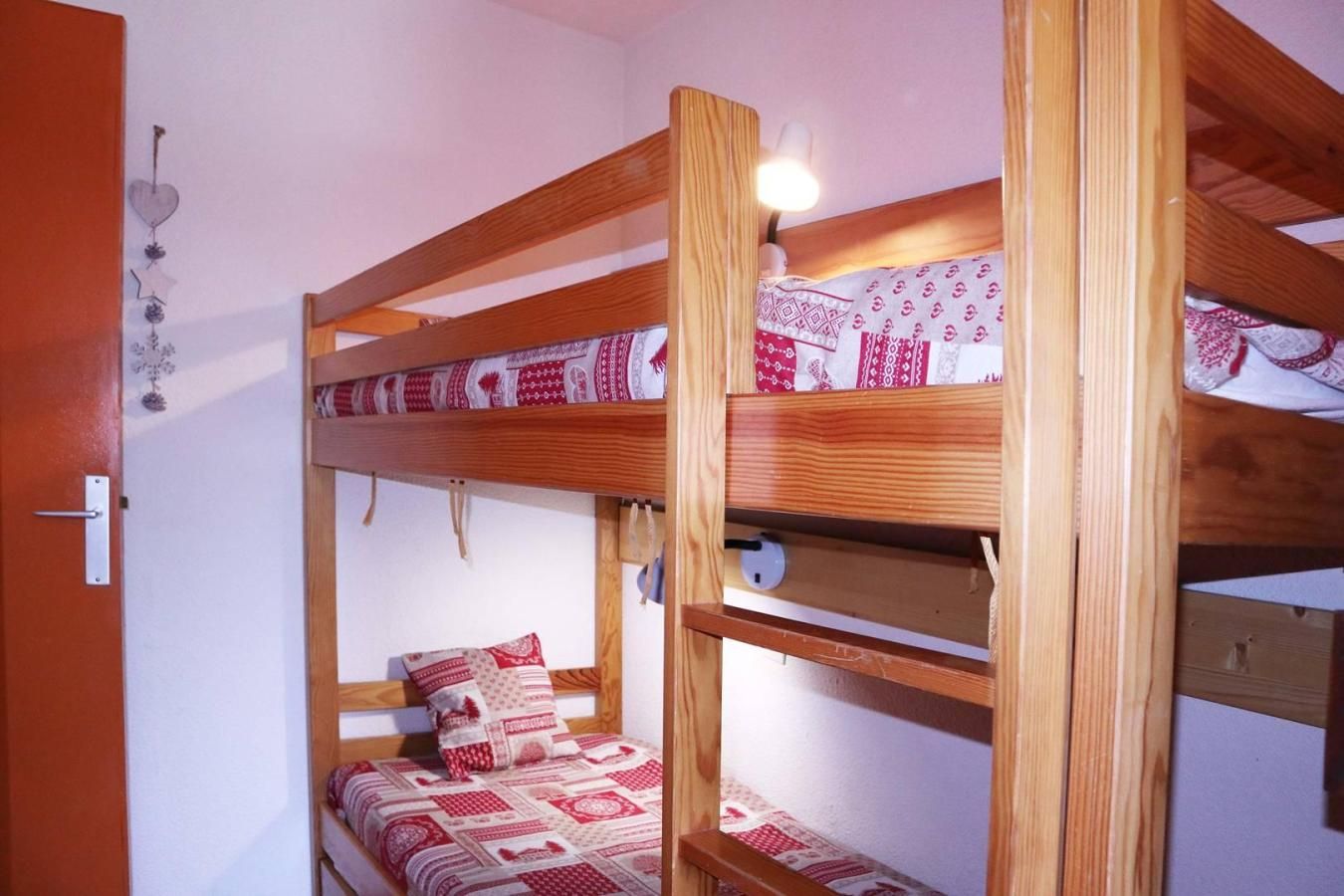 Ein Stockbett mit Holzrahmen und einem gemusterten Bettbezug.