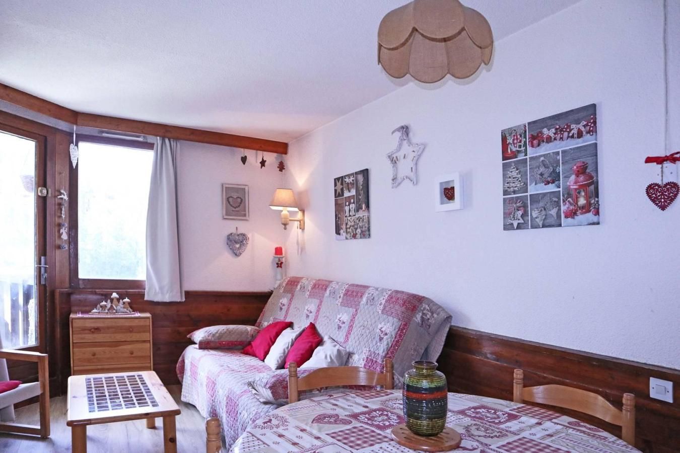 Une chambre confortable avec un lit, une table de chevet, une lampe et une fenêtre avec des rideaux.