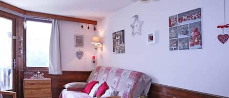 Ein gemütliches Schlafzimmer mit einem Bett, einem Nachttisch, einer Lampe und einem Fenster mit Vorhängen.