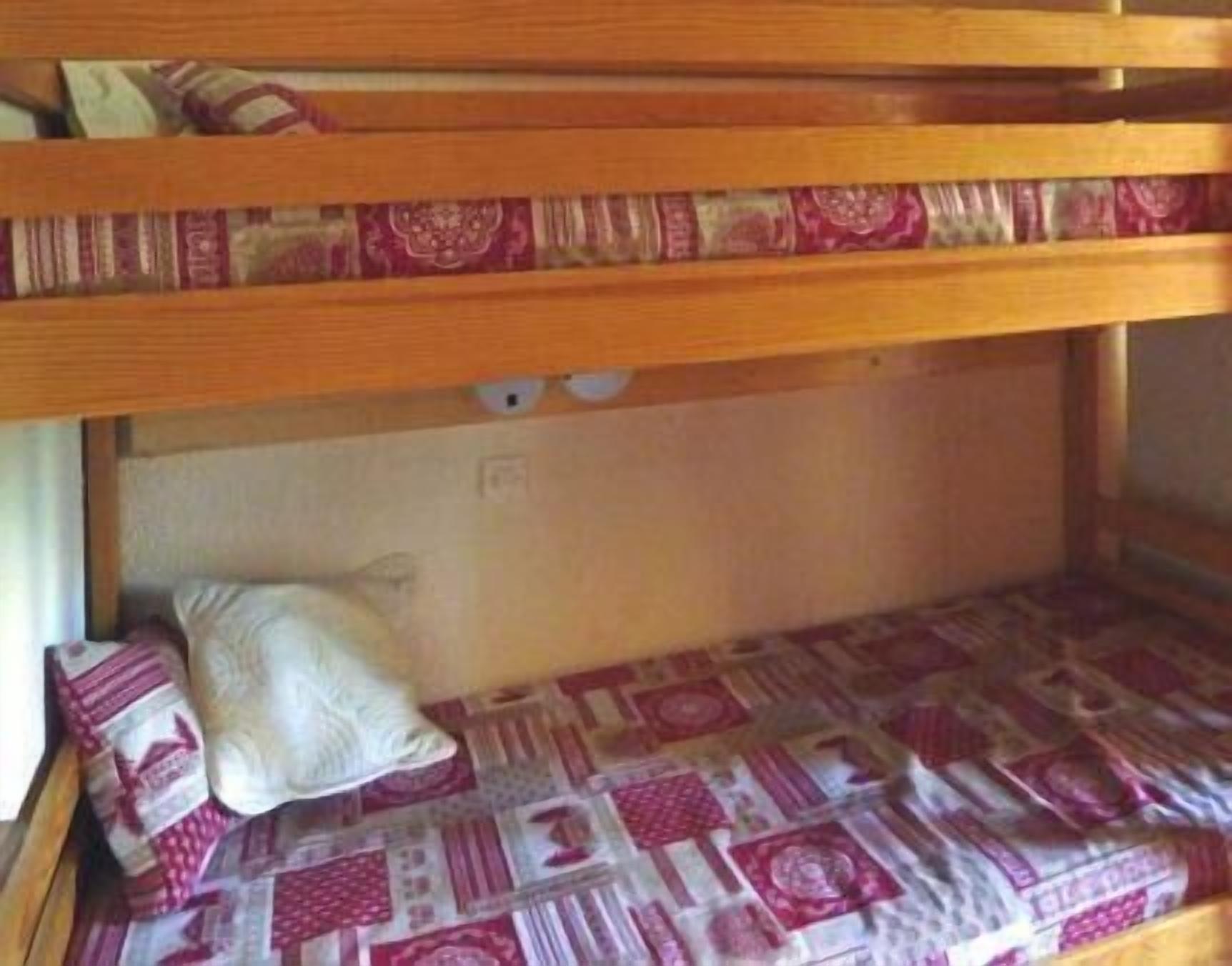 A bunk bed with patterned bedding and pillows.