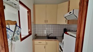 A compact kitchen with beige cabinets, a sink, and a stove. - Ski-in/ski-out & foot of the slopes, 1st floor, balcony, tv, ski locker, 38m², Les Orres (Les Orres)