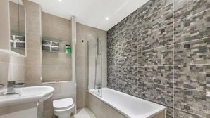 A modern bathroom with a shower, toilet, and sink. - Newly Refurbished 1 Bedroom Whitechapel (London)