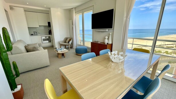 A modern hotel room with a dining area, a sofa, a TV, and a view of the beach. - Superb view of the ocean, the beach at your feet! (Soorts-Hossegor)