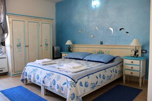A bedroom with a bed, two nightstands, a wardrobe, and a wall with bird decals. - Sabbia e Mare (Porto Torres)